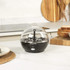 Black electric egg cooker with clear lid on kitchen counter