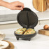 Black electric waffle maker with two non-stick compartments, open and empty