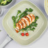 Square grill pan with sliced cooked chicken breast, broccoli and cherry tomatoes.