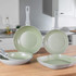 Set of Salter non-stick green pans with cooked food, displayed on white worktop