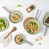 Green non-stick frying pan with cooked chicken stir fry and vegetables.