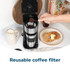 Black Salter coffee maker on countertop with hand placing lid on stainless steel travel mug