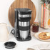 Stainless steel travel mug with black lid in a car cup holder