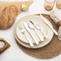 Table setting with cream stoneware plate, woven placemat, linen napkin and silver cutlery