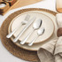 Breakfast setting with stoneware plate, bread with jam, and stainless steel cutlery