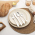 Set of four silver cutlery pieces on cream stoneware plates, for product listing