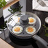 Non-stick egg poaching pan with four eggs cooking under glass lid on a hob