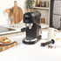 Black Salter espresso coffee machine on kitchen counter, shown with coffee grounds and breakfast bagel.