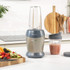 Salter silver blender with supersized blending cup filled with fruit, surrounded by smoothies and ingredients