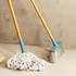 Mop and broom with light wooden handles and blue plastic heads on neutral background