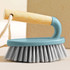 Handheld scrubbing brush with light wood handle and blue plastic body