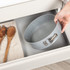 Non-stick grey bakeware set with assorted foods displayed on a kitchen counter