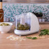 White mini food processor blending green pesto on kitchen worktop