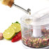 White electric mini food chopper with chopped vegetables, shown on a kitchen worktop