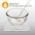 Digital kitchen scale shows milk splash in glass bowl, demonstrating liquid measurement feature.