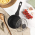 Set of Salter black-handled saucepans and frying pan in use, view from above