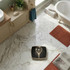 Mechanical bathroom scale with gold trim on marble floor