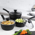 Set of three black non-stick saucepans with glass lids, shown with fresh vegetables.