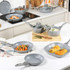 Set of grey non-stick pans and pots with food, shown in a modern kitchen