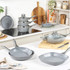 Set of grey stone-effect non-stick pans and frying pans on a modern kitchen worktop