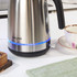 Stainless steel electric kettle with blue LED light, Salter brand, kitchen setting.