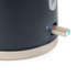 Close up of a dark grey kettle base with blue power light and metallic switch
