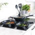 Set of three black non-stick frying pans on induction hob, shown cooking vegetables and meat