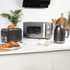Gunmetal kettle, toaster, and microwave set on kitchen counter