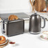Gunmetal two-slice toaster with toasted bread and matching electric kettle on kitchen counter
