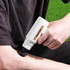 White Salter massage gun used on forearm, shown in close-up for product detail.