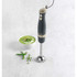 Grey hand blender with stainless steel blade beside bowl of green soup and peas.