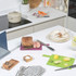 Set of colour-coded chopping boards with knives on kitchen counter, ready for food prep