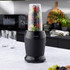 Black Salter blender in kitchen, pouring red fruit smoothie into tall glass