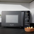 Black microwave oven with digital controls on kitchen worktop