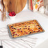 Grey speckled rectangular oven tray with raised edges, shown at an angle