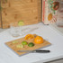 Bamboo chopping board with citrus fruits and knife on kitchen counter