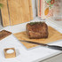 Kitchen scene with three bamboo chopping boards, roast beef, sliced lemons and limes, and water glasses