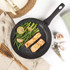 Non-stick frying pan with cooked salmon fillets and green beans, shown from above.