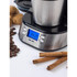 Stainless steel digital coffee grinder on white surface with cinnamon sticks and cookies.