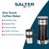 Stainless steel digital coffee grinder on white surface with cinnamon sticks and cookies.