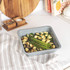 Set of grey non-stick bakeware including trays, tins, roaster and muffin pan on kitchen counter