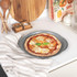 Grey non-stick perforated pizza tray shown flat, ideal for baking crispier pizza bases