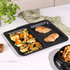 Non-stick oven tray with divider, shown with baked chicken breast and mixed roasted vegetables