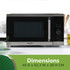 Roast chicken with vegetables being removed from a silver microwave oven with oven gloves