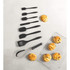 Set of seven black-handled baking utensils beside five scones on cooling rack and table.