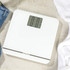 White digital bathroom scale with large display on tiled floor