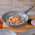Set of two grey non-stick frying pans with speckled finish, shown side by side.