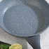 Grey non-stick frying pan with speckled finish, shown from above on worktop