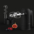 Black electric hand mixer with beaters, dough hooks, storage stand and assorted berries.