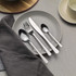 Set of four stainless steel cutlery pieces on marble surface